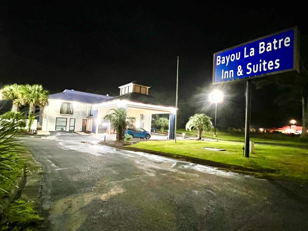 Bayou La BatreBayou Inn & Suites的夜间房子前面的街道标志