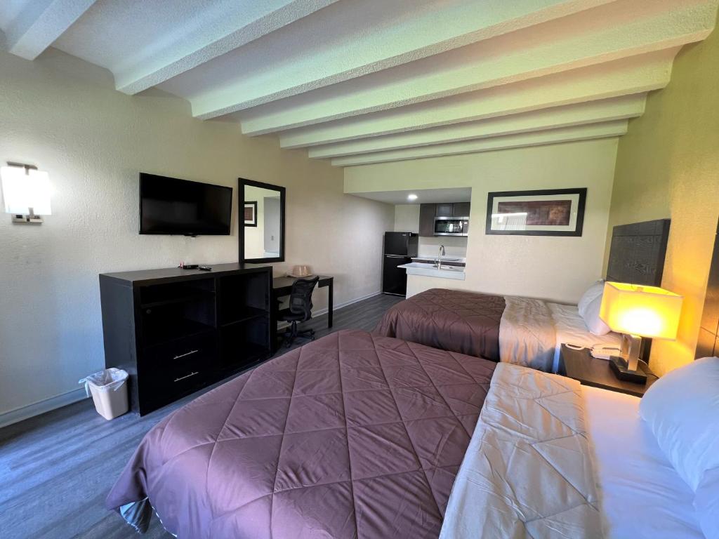 纽波特纽斯James River Inn & Suites的酒店客房设有两张床和一台平面电视。