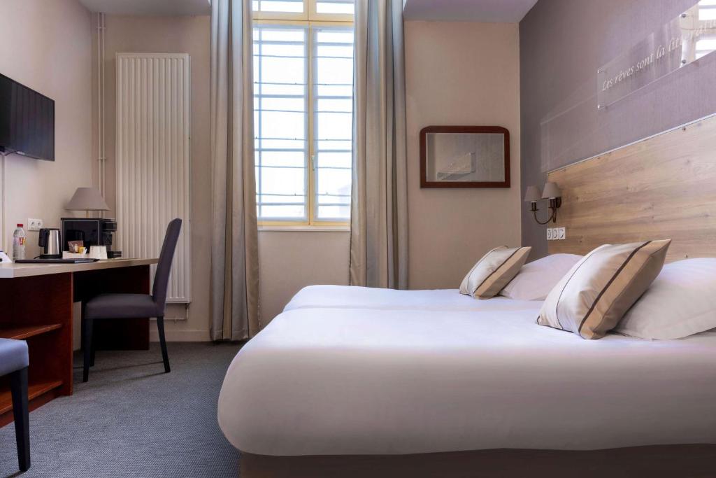 蒙特勒伊贝斯特韦斯特厄尔米塔奇酒店的酒店客房设有一张大床和一张书桌。