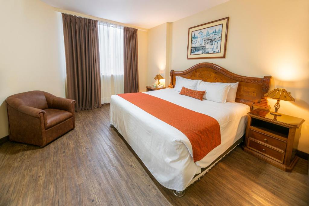 利马米拉弗洛雷斯科隆酒店的酒店客房带一张大床和一把椅子