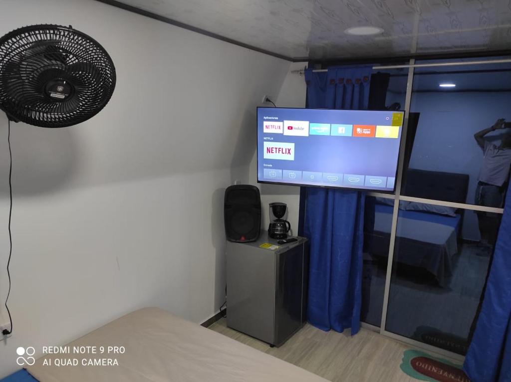 梅尔加Cabañas Mirador La Roca的客房设有1张床、1台电视和1台风扇。