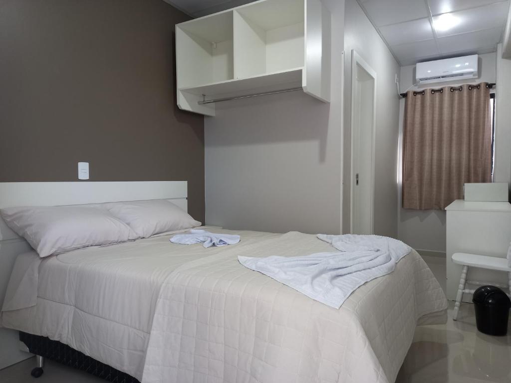 CaçadorSognare Hotel的一间卧室配有一张带白色床罩的床