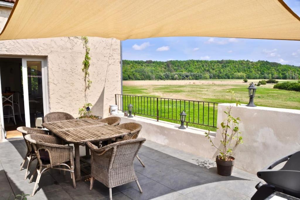 努瓦埃尔confortable maison familiale à l'entrée du village médiéval的庭院配有桌椅,享有田野美景。