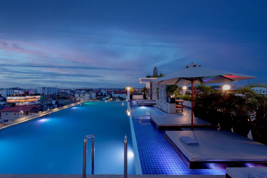 暹粒Two Seasons Siem Reap Hotel的游泳池,晚上可欣赏到城市景观