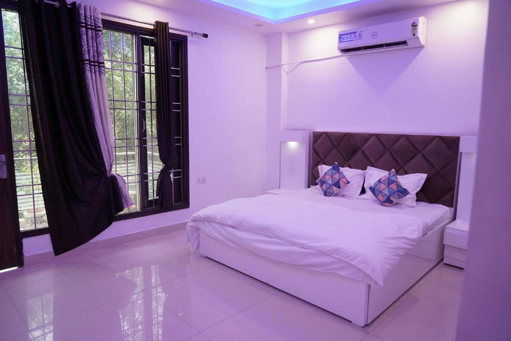 新德里Own Stay的卧室配有白色的床和窗户。