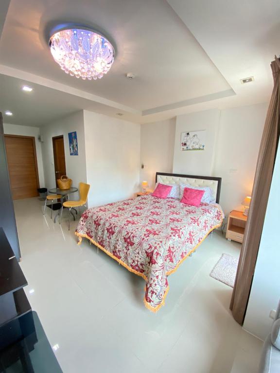 乔木提恩海滩Beach 7 Condo, Pattaya的卧室配有一张带粉红色枕头的大床