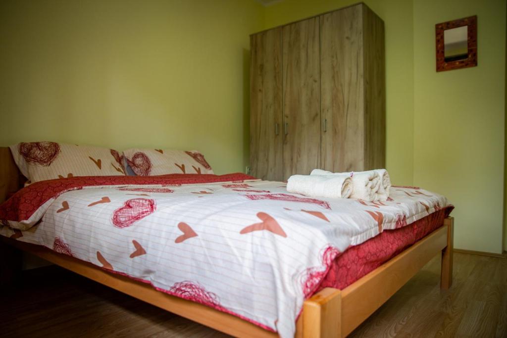 索科矿泉村Beli Ocnjak的一间卧室配有一张带白色和红色棉被的床