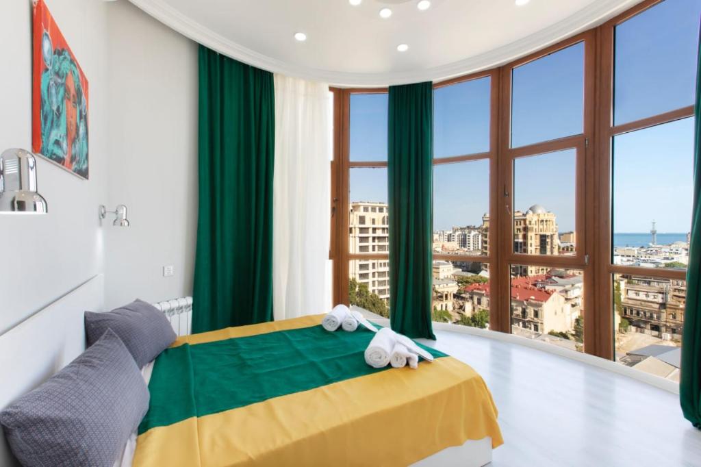 巴库Leyla Apartments 2的一间卧室设有一张黄色和绿色的床,配有大窗户