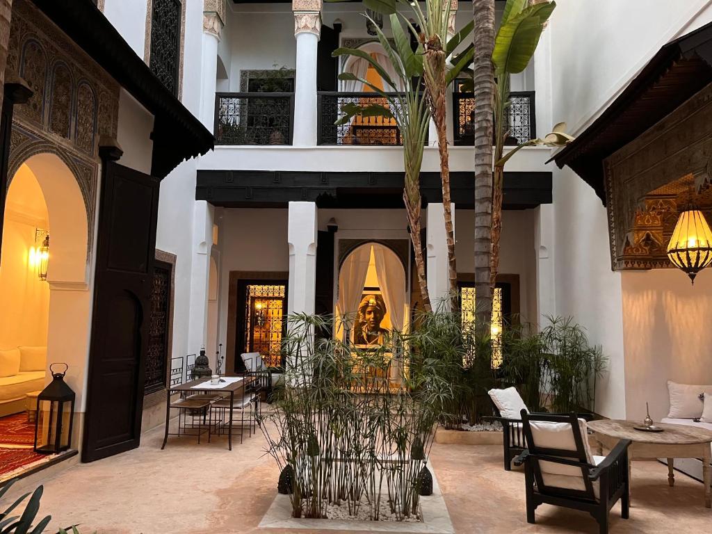 马拉喀什RIAD ENNAFOURA BOUTIQUE HOTEL的庭院配有桌椅和棕榈树