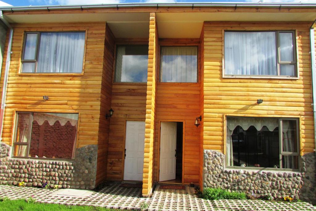 科伊艾科Cabañas Ancestros的一座木房子,设有两扇门和两扇窗户
