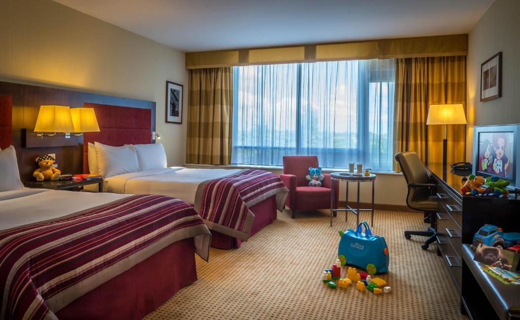 阿什本Pillo Hotel & Leisure Club的酒店客房,配有两张床和椅子