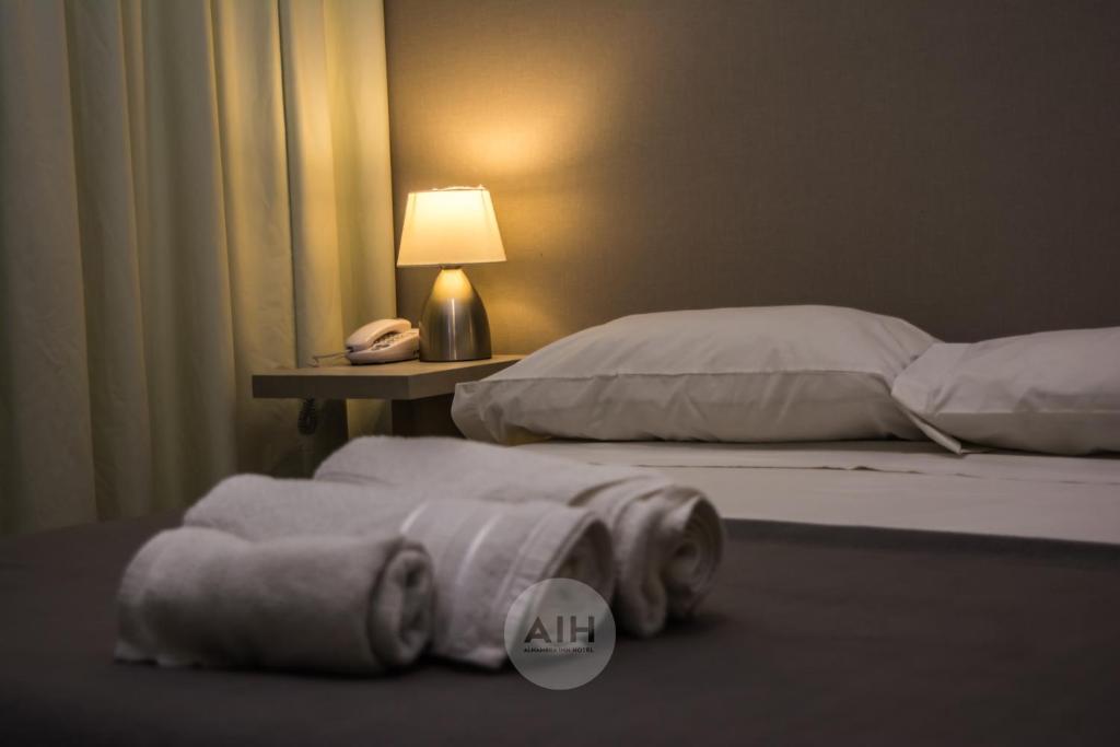 圣胡安Hotel Alhambra的一间卧室设有两张床,桌子上配有一部电话
