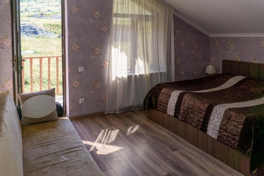 卡兹贝吉Hotel Diamond Kazbegi的一间卧室设有一张床和一个阳台