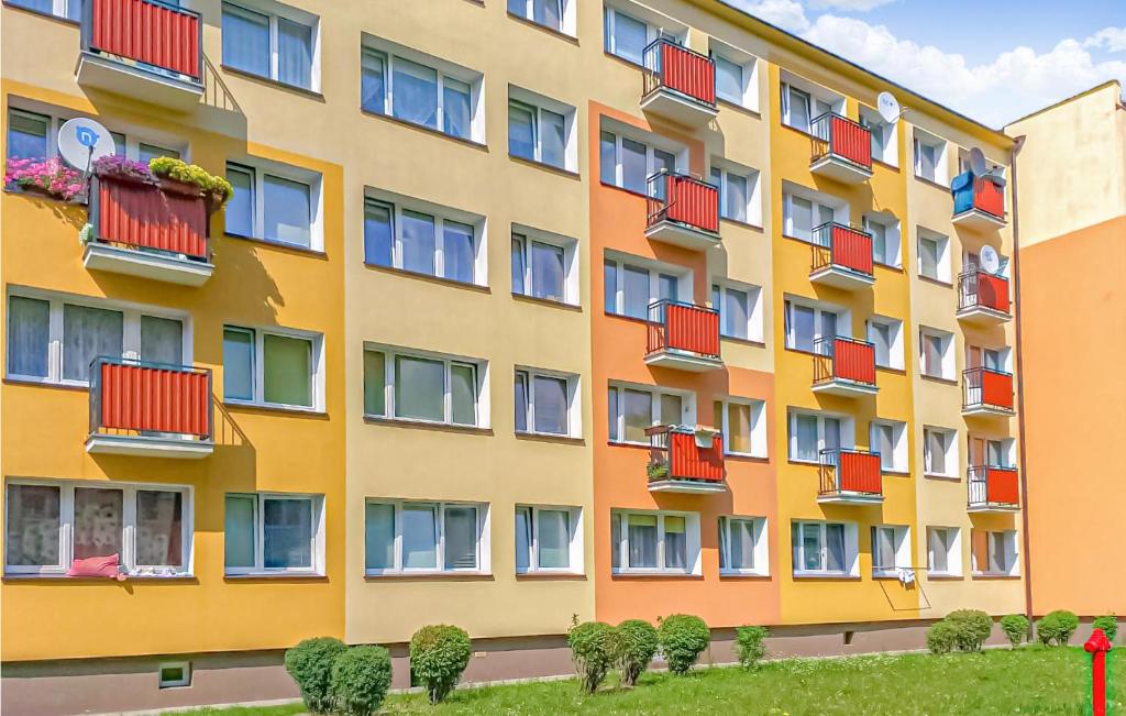 科沙林2 Bedroom Cozy Apartment In Koszalin的一座高大的建筑,上面有红色的阳台