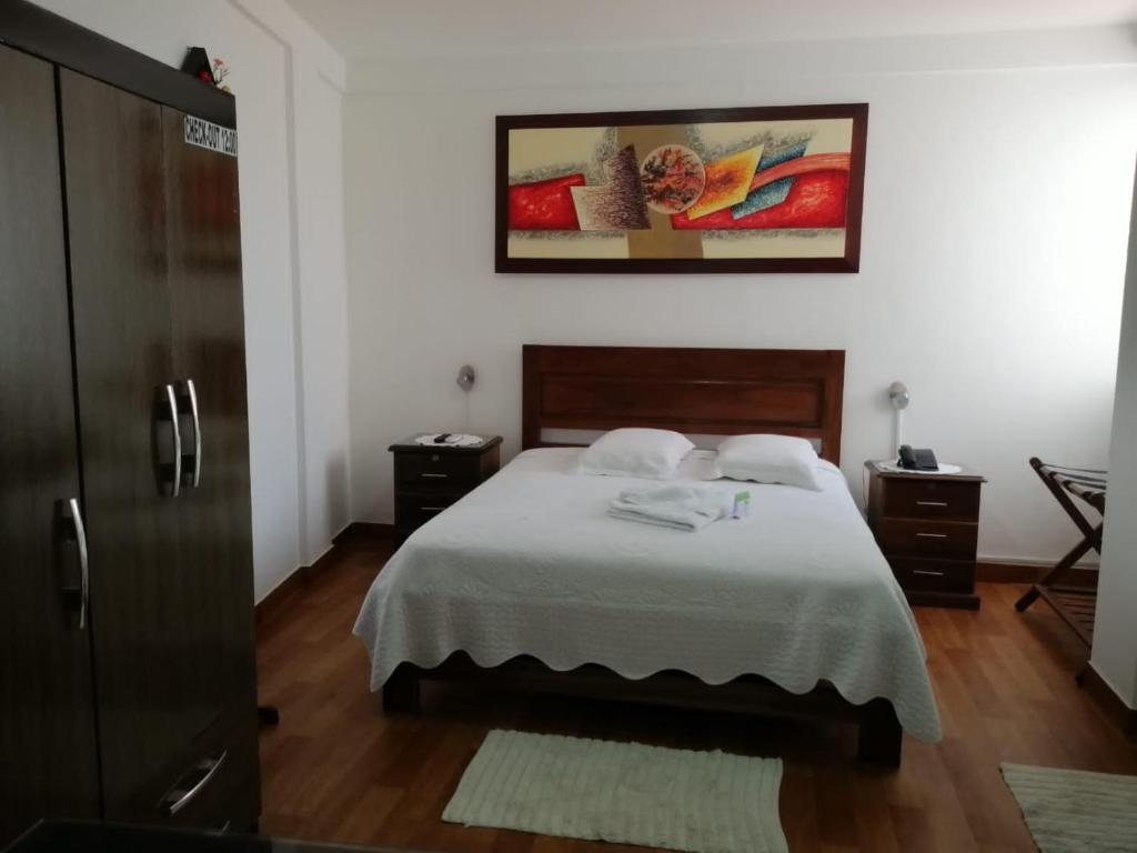 圣克鲁斯Buen Retiro Apart Hotel的一间卧室配有一张床,上面有两条毛巾