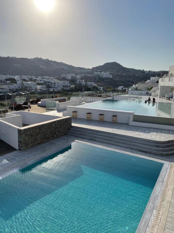 普拉迪斯亚罗斯The George Hotel Mykonos的大楼内的一个蓝色海水大型游泳池