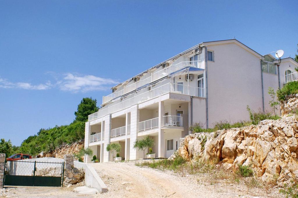 克勒克Apartments by the sea Komarna, Neretva Delta - Usce Neretve - 2739的岩石山上一座白色的大建筑