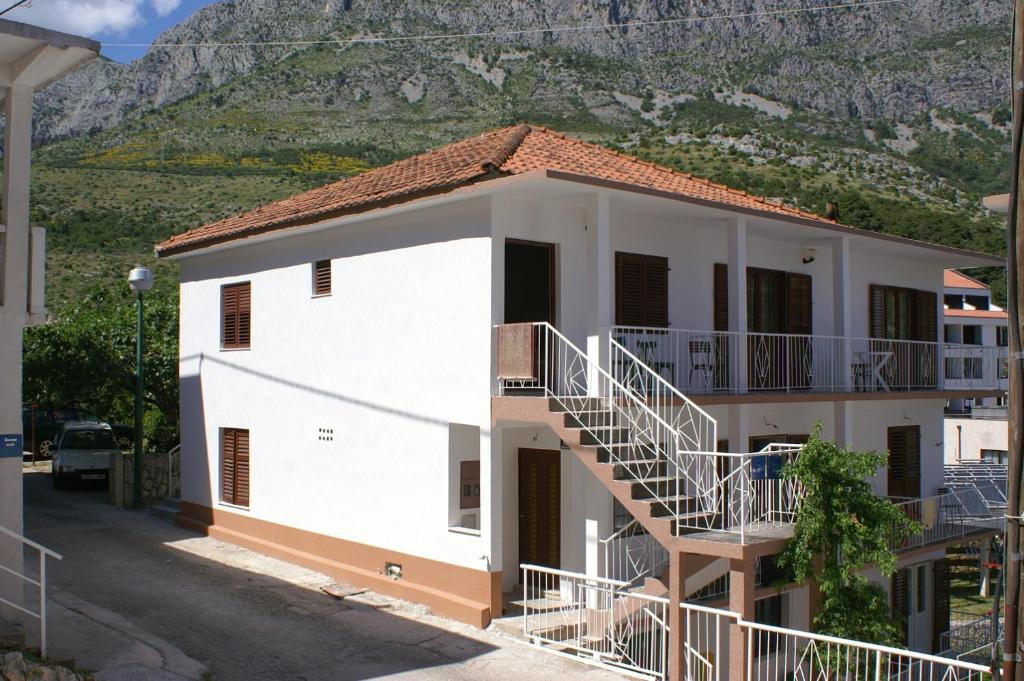 德尔韦尼克Apartments by the sea Drvenik Donja vala, Makarska - 2732的一座白色的建筑,在山前有楼梯