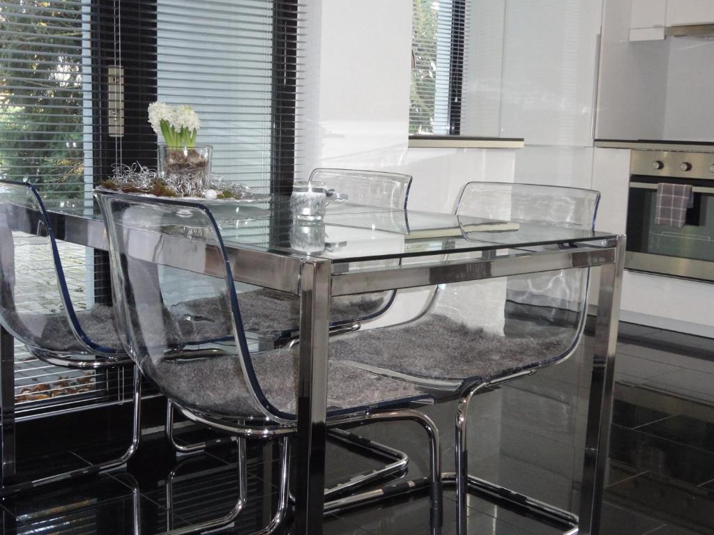 诺伊斯诺伊斯黑与白公寓的厨房里配有玻璃餐桌和四把椅子