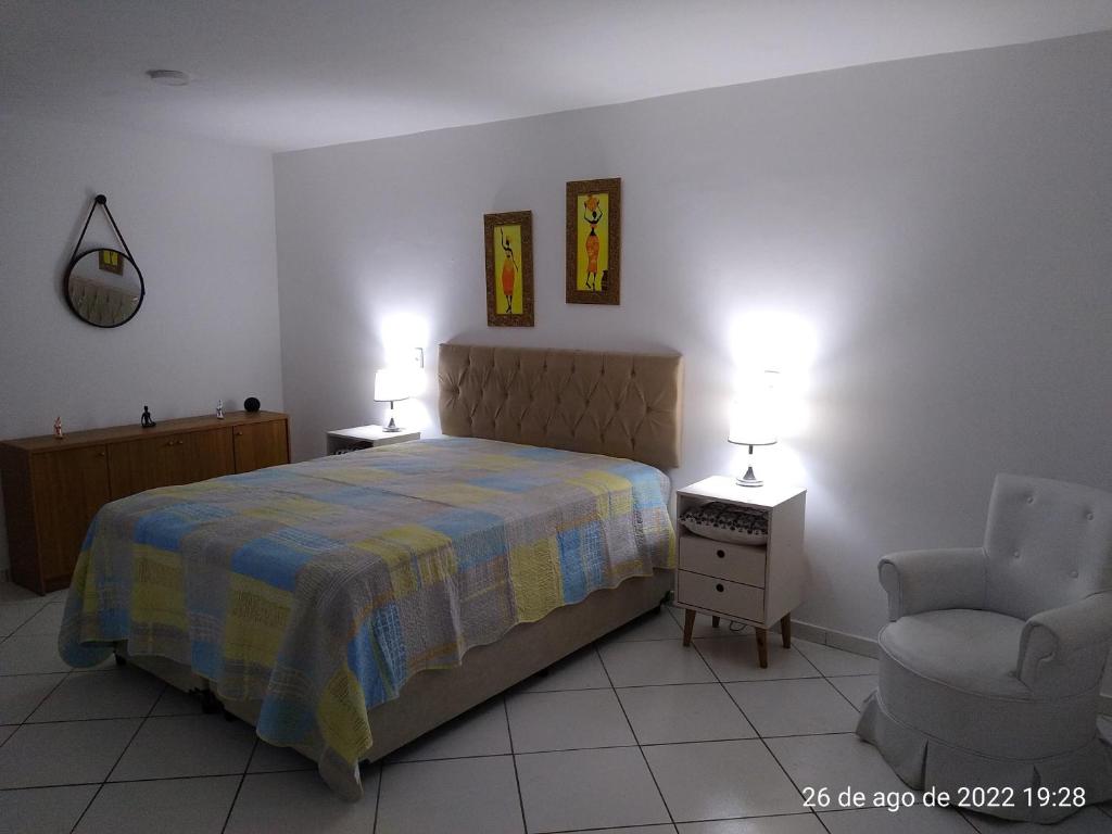 里约热内卢Cantinho Bonsai的卧室配有床、椅子和灯