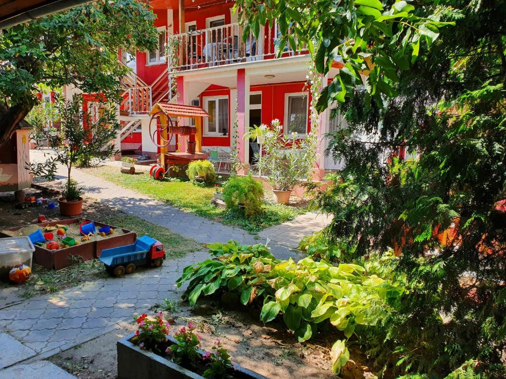 什图罗沃Apartmány Viola的一座花园,位于一座红白色房子前面