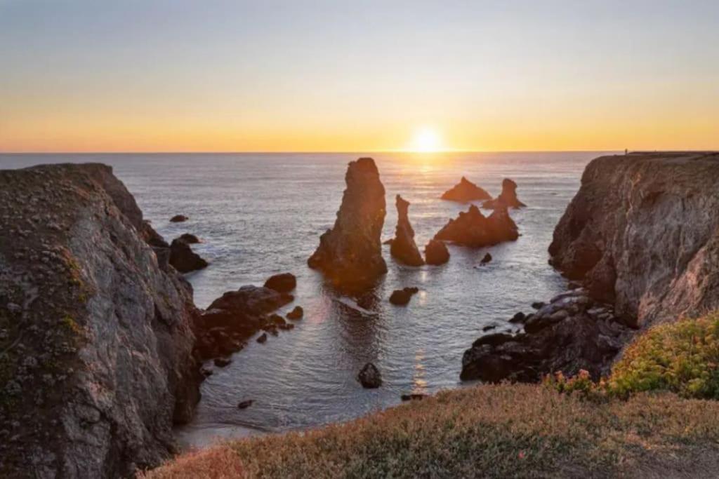 索宗Maison entre Terre et Mer avec Jacuzzi的日落时分海洋中的岩石群
