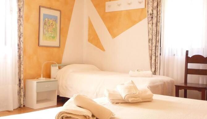 Moggio UdineseLOCANDA SAN GALLO的酒店客房设有两张床和窗户。