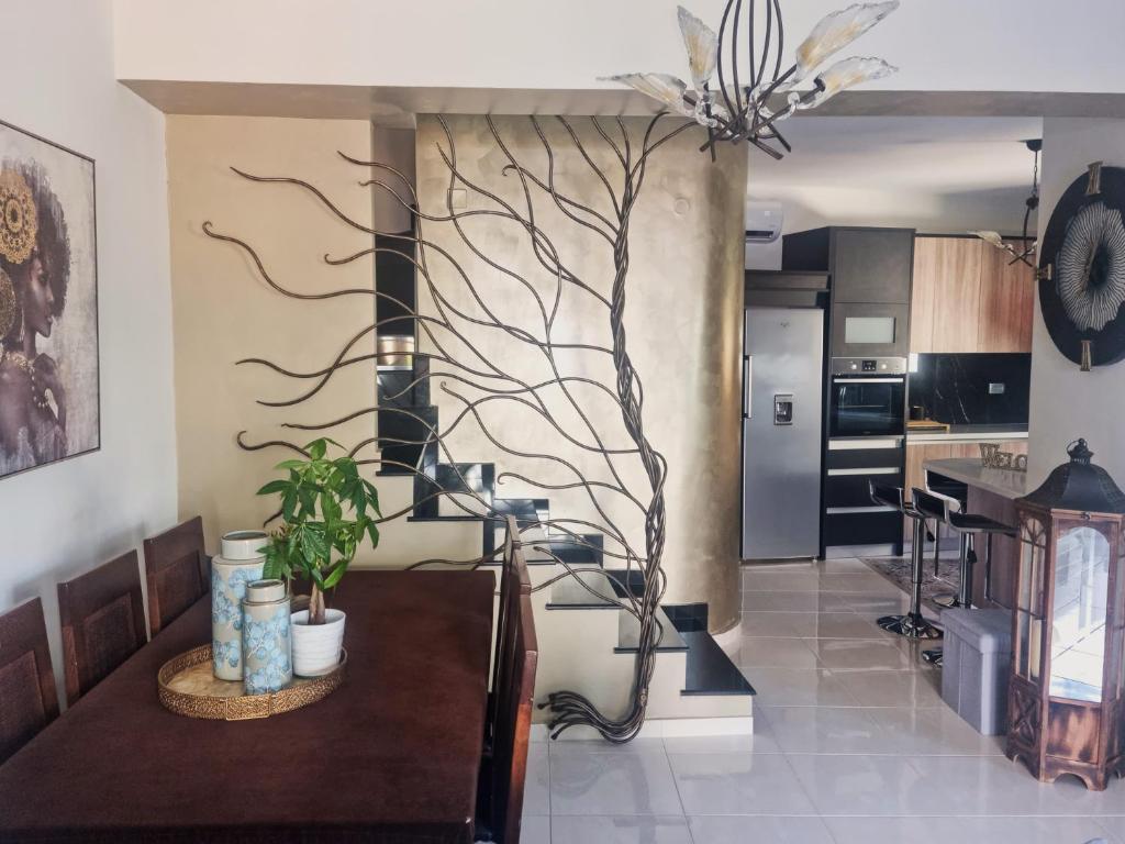 基萨莫斯Villa Vanessa的厨房配有桌子,墙上挂着一棵树