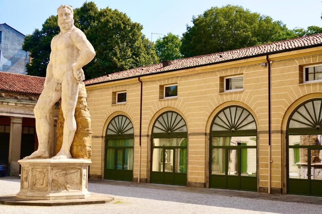 帕多瓦Palazzo Mantua Benavides Suites & Apartments的建筑物前的一个人雕像