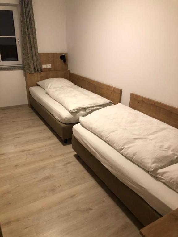 绍埃尔拉Pension Beil的铺有木地板的小客房内的两张床