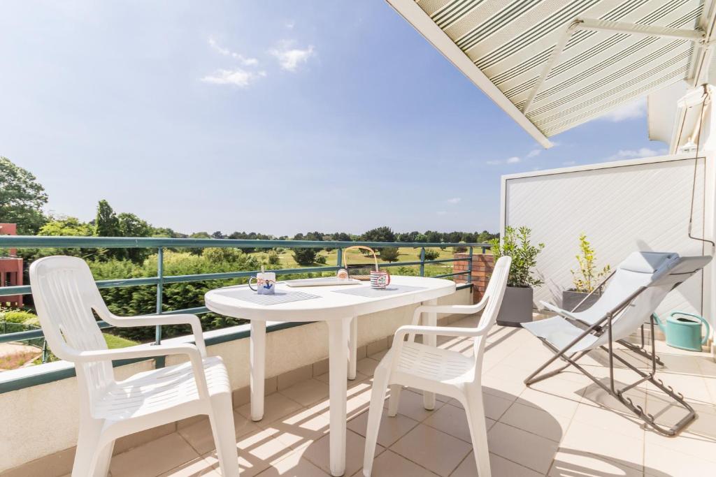 波尔尼克La Terrasse du golf的阳台的庭院配有白色的桌椅