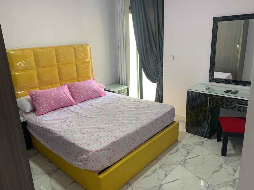 塞得港بورتو سعيد Portosaid的一间卧室配有一张带粉色枕头的床和电视。
