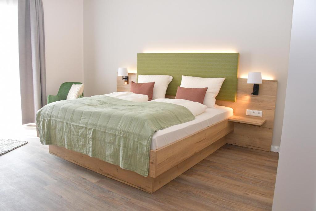 BasthorstLandhaus Hamester - Hotel & Restaurant - neu eröffnet September 2022的一间卧室配有一张带绿色床头板的床