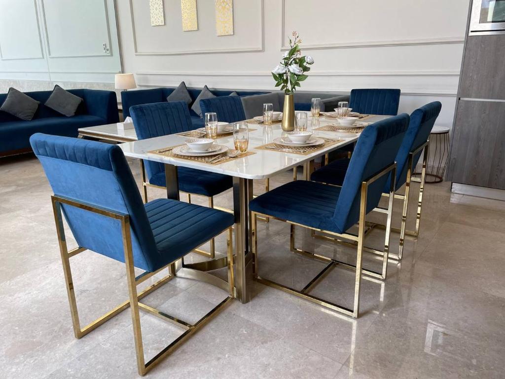 阿可贺巴شاليه المنى - الخبر - للعائلات的一间带桌子和蓝色椅子的用餐室
