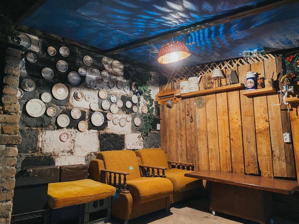 久姆里Unoyan Guest House的一间墙上配有桌椅和盘子的房间