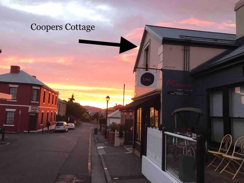 霍巴特Coopers Cottage Battery Point的日落时分街道景观与单词coopers小屋