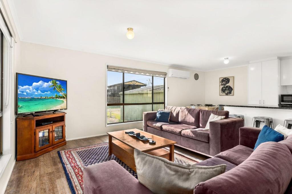 日落大道Panoscape的客厅配有两张沙发和一台电视机