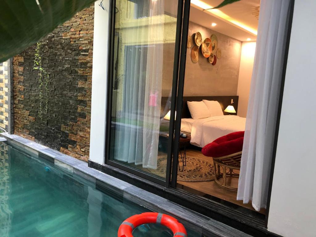 会安PHỐ CHỢ ĐÊM Villa的一间卧室设有一张床和一个游泳池