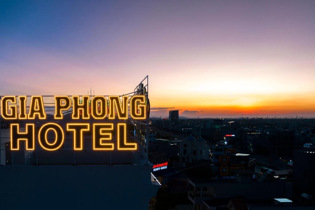 Xóm NiêmGia Phong Hotel的建筑顶部的标志,背景是日落