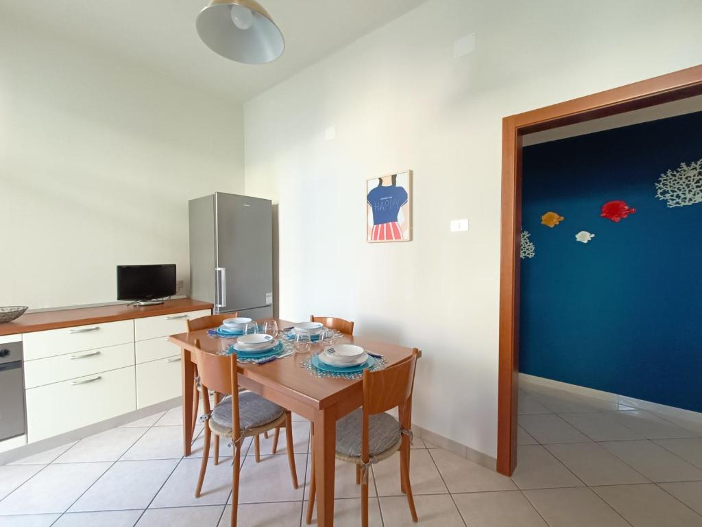 莫诺波利TRE PESCIOLINI HOME的厨房配有桌椅和蓝色的门