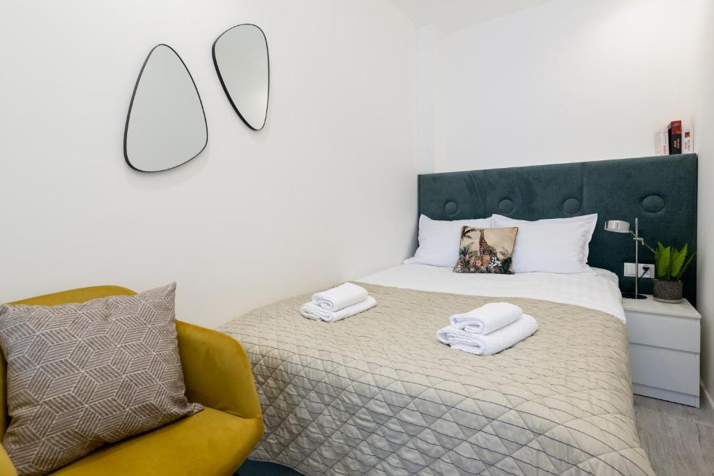 别尔斯克-比亚拉Apartamenty Prestige Centrum的一间卧室配有一张床和一张黄色椅子