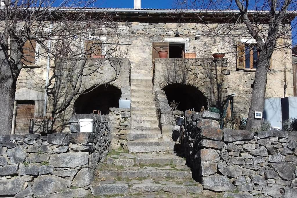 卡拉库恰Maison de caractère au coeur de la corse rurale的石头建筑,有楼梯和石墙