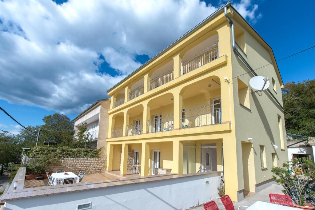 德拉马利Apartments with a parking space Dramalj, Crikvenica - 5592的黄色房子的顶部设有阳台