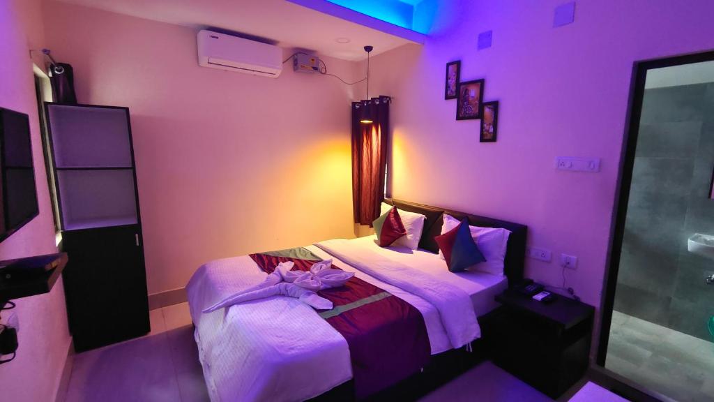 布巴内什瓦尔THE GREENSTAR INN PREMIUM的一间卧室配有带一张床的紫色客房