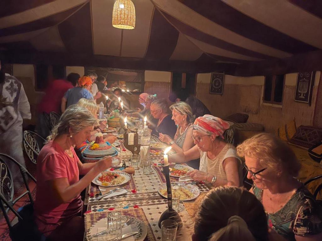 扎古拉berber sahara的一群坐在餐桌上吃食物的人