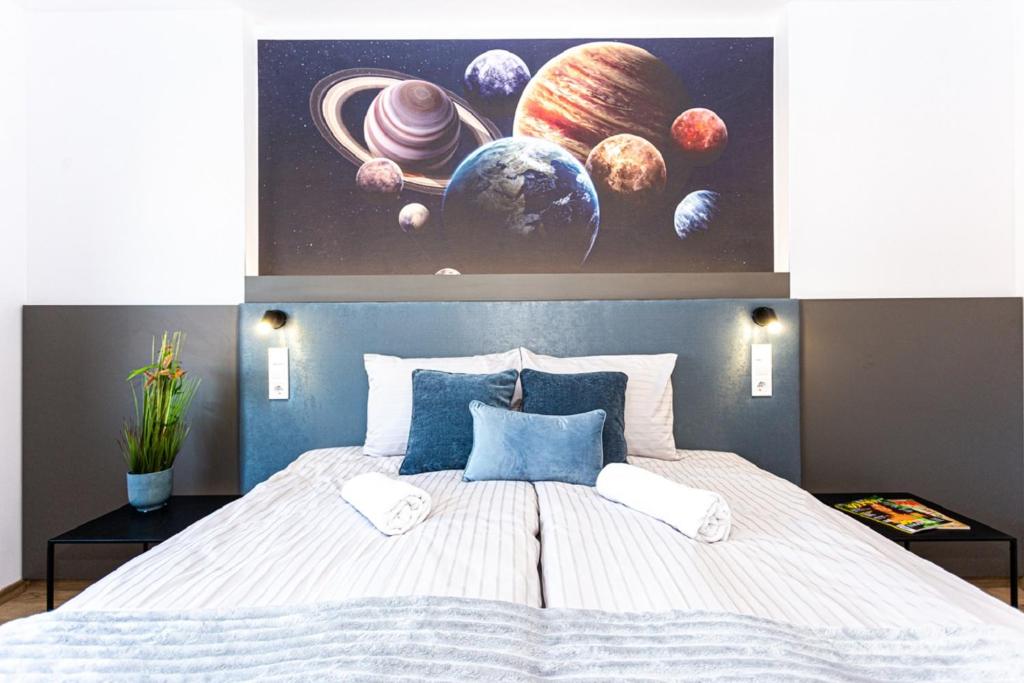 佩奇R73 Residences的一间卧室配有一张大床,上面画着行星