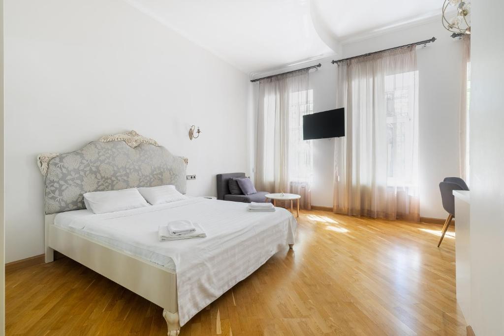 敖德萨KayKay Apartments的白色卧室配有床和椅子