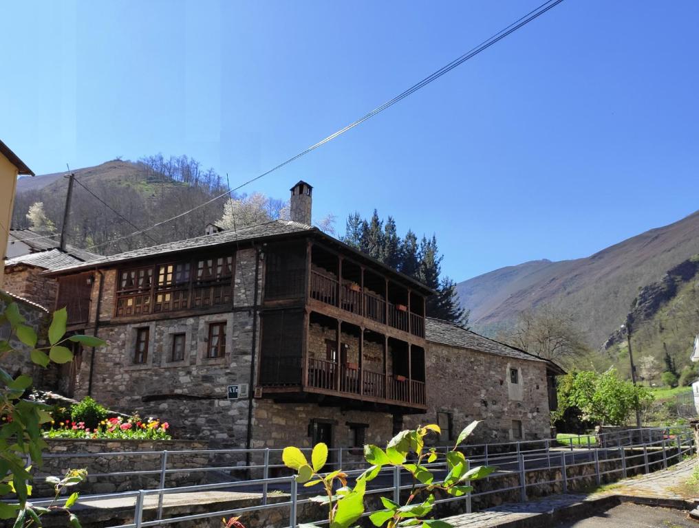 Rengos塞波乡村民宿的一座古老的石头建筑,设有阳台,享有山脉的背景