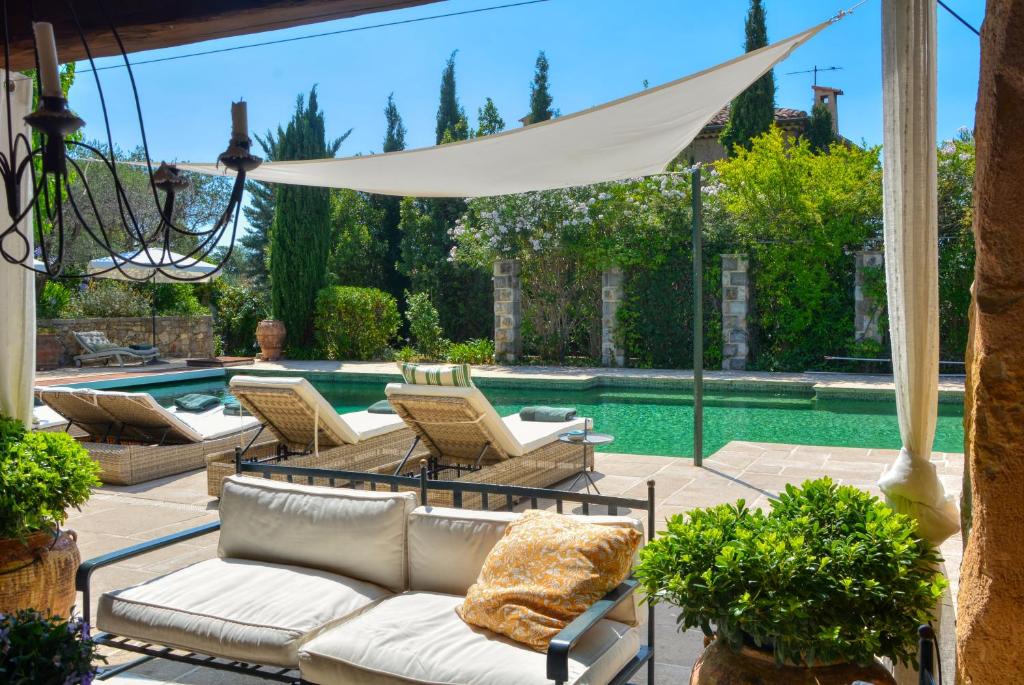 法扬斯La Maison de Platane B&B的一个带椅子的庭院和一个游泳池
