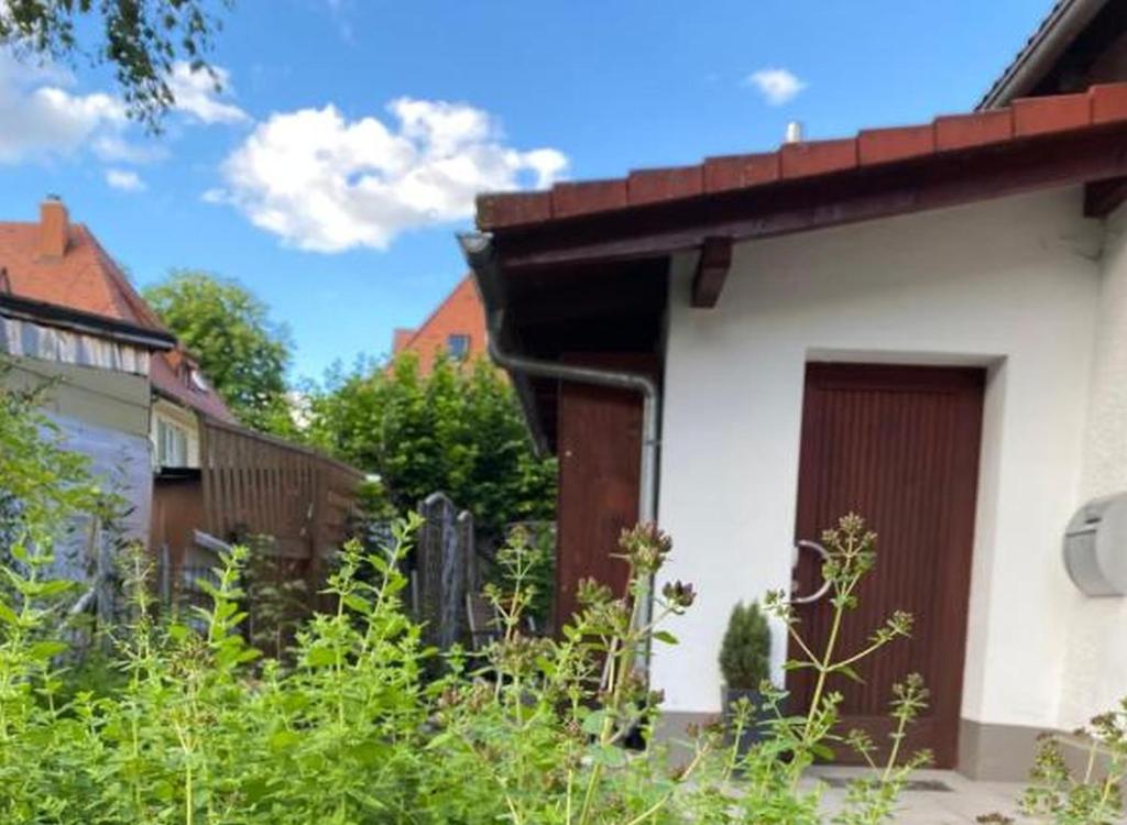 多瑙艾辛根Ferienwohnung an der Brigach的一座白色的建筑,在院子里设有棕色的门